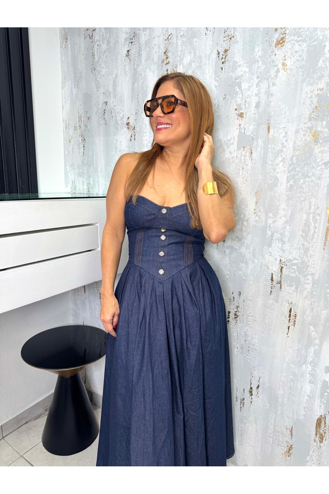 A denim midi dress featuring strapless sweetheart neckline, bustier bodice with button detail, basque waist, full skirt and back zipper closure