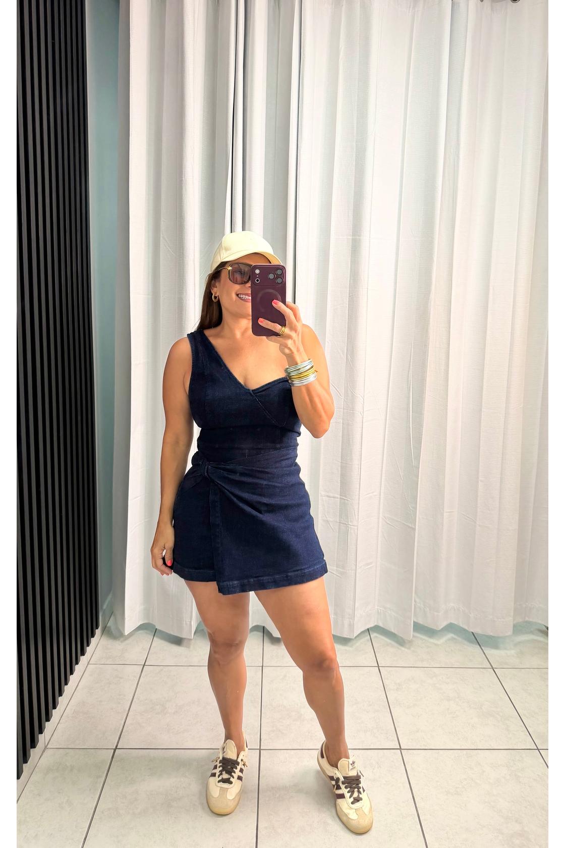 Denim skort romper featuring one shoulder neckline, front twist bottom and back zipper closure