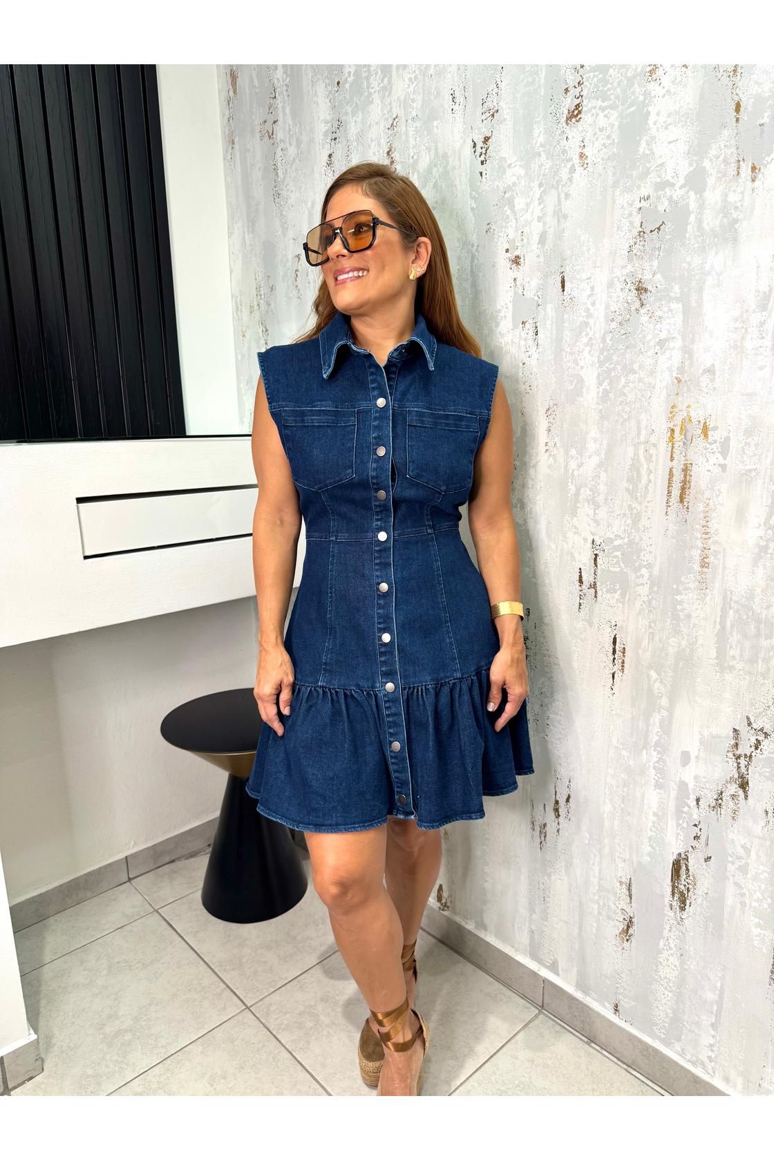 Selina washed denim mini dress featuring collar, sleeveless, front pocket, button down and ruffled hem.
